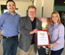 Image of Team Vidak members Rogelio Caudillo and Paula Vinzant presenting a Senate Certificate of Recognition to Dr. Michael Gunson.